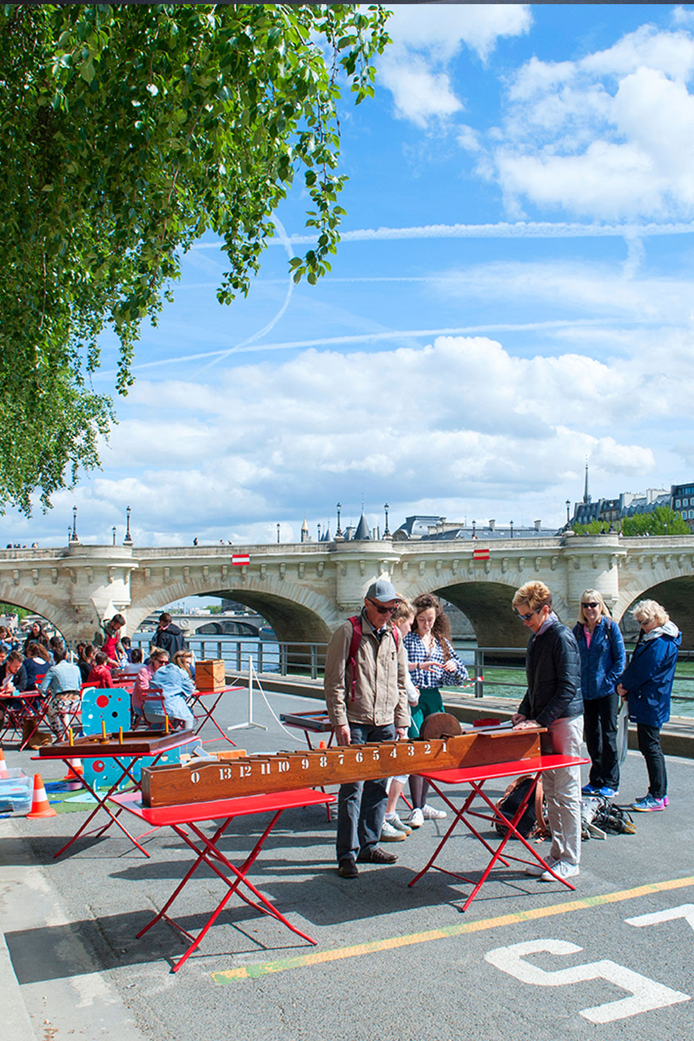 People meeting for play games on the quay along the Seine River in Paris