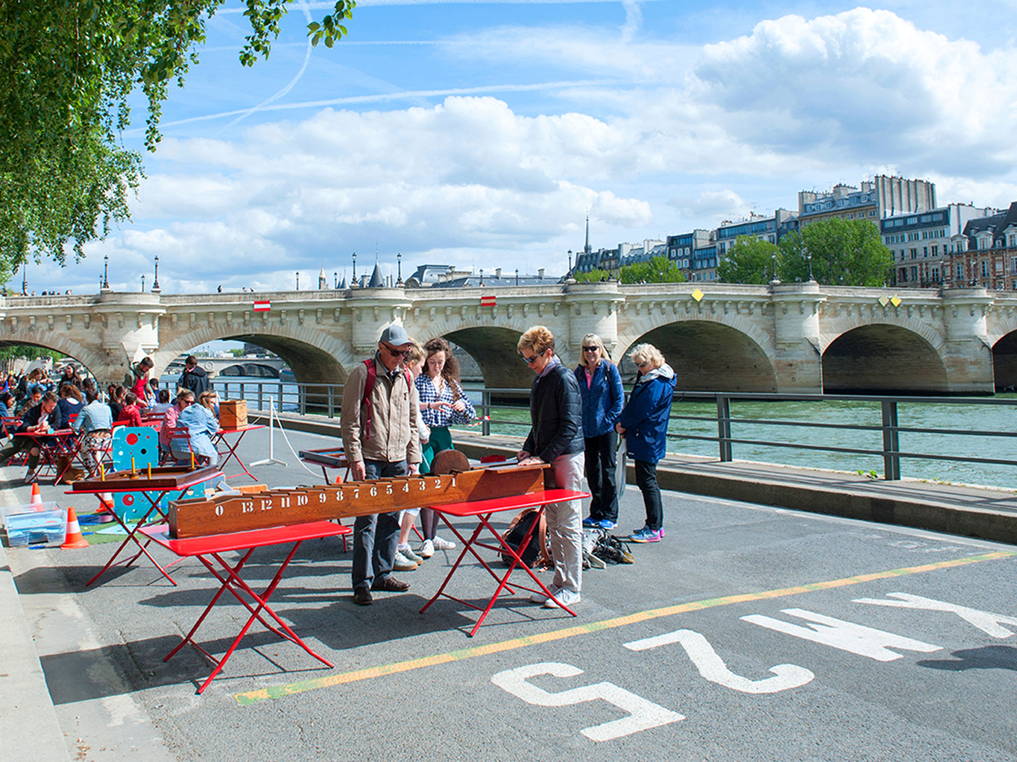 People meeting for play games on the quay along the Seine River in Paris