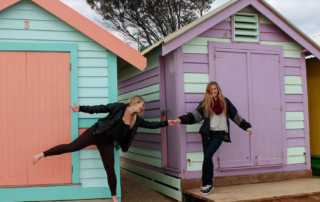 Two college students in front of colorful houses