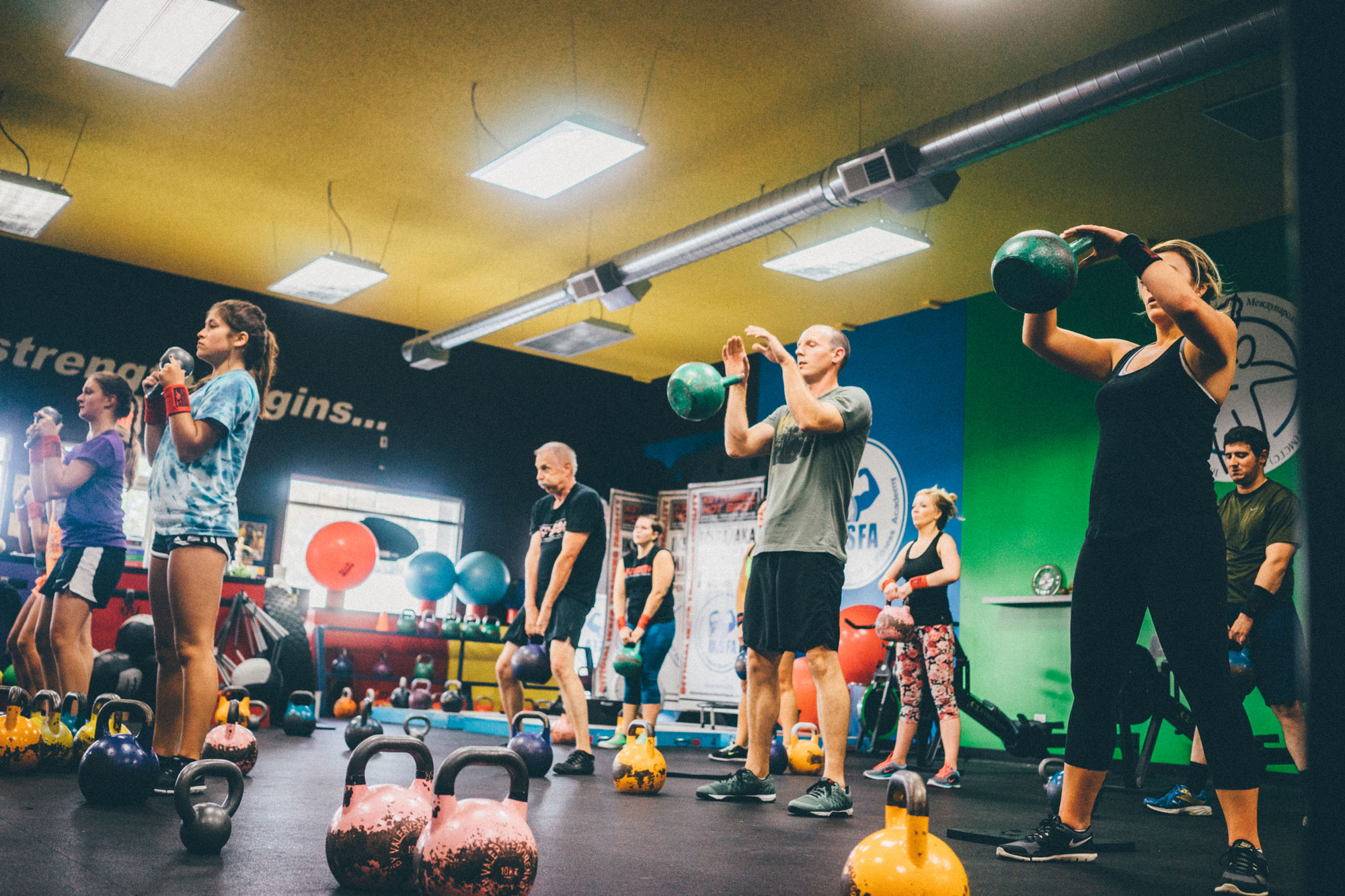 People working out in a gym setting with kettle bells