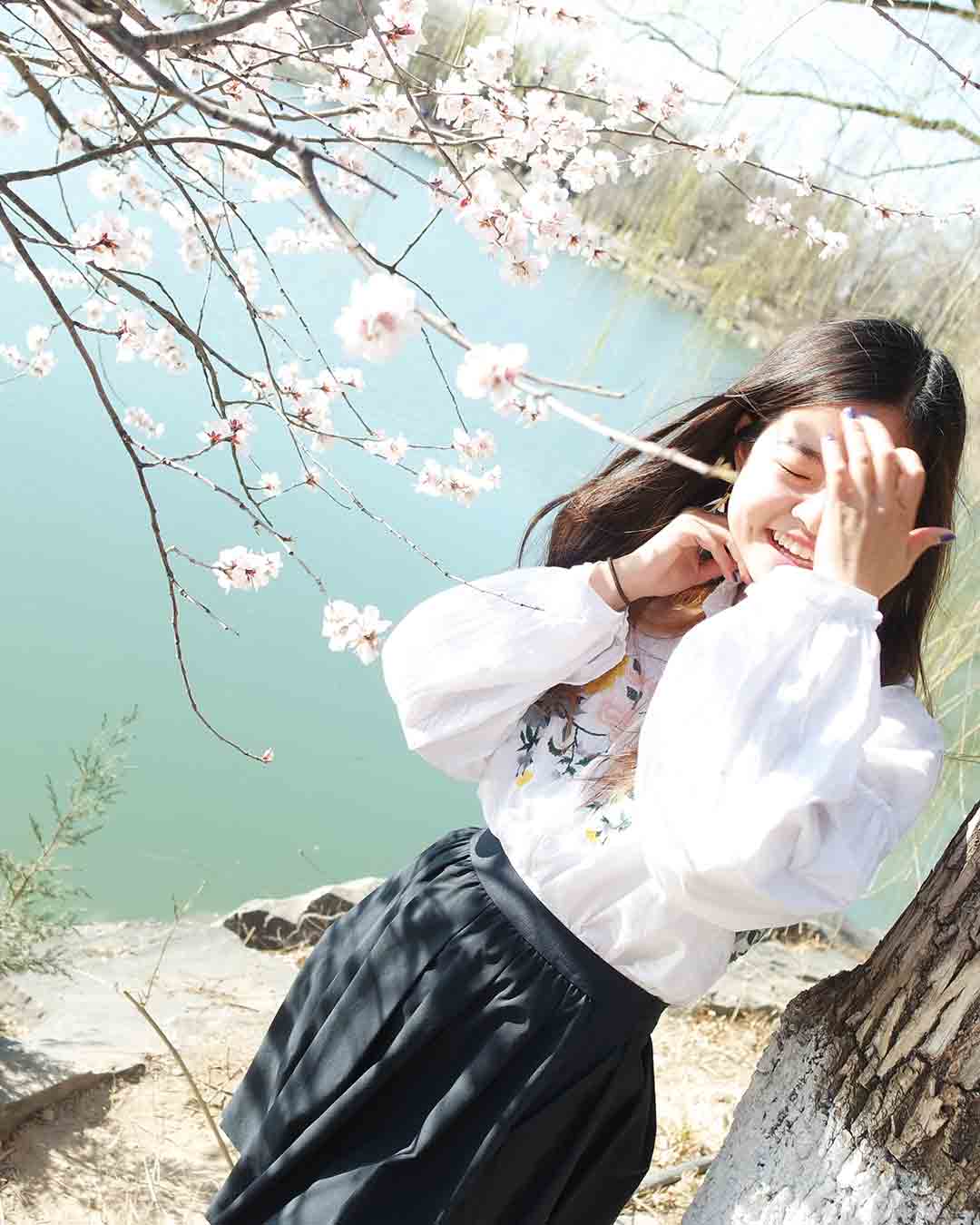 Anna laughing with cherry blossom trees in the background