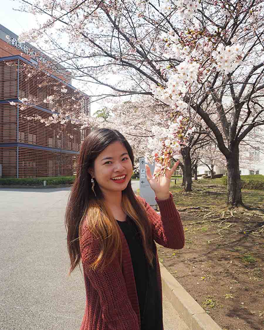 Anna posing next to cherry blossoms