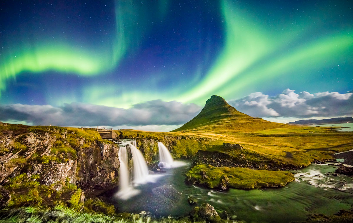 View of aurora over Kirkjufell and waterfall. Idyllic view of Northern Lights in Iceland.