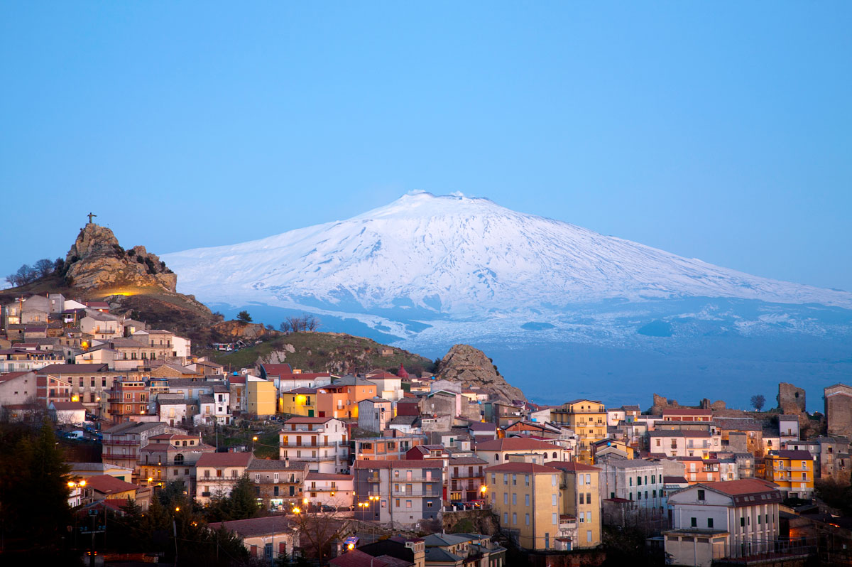View of the village of San Teodoro and Etna volcano on background. Sicily, Italy