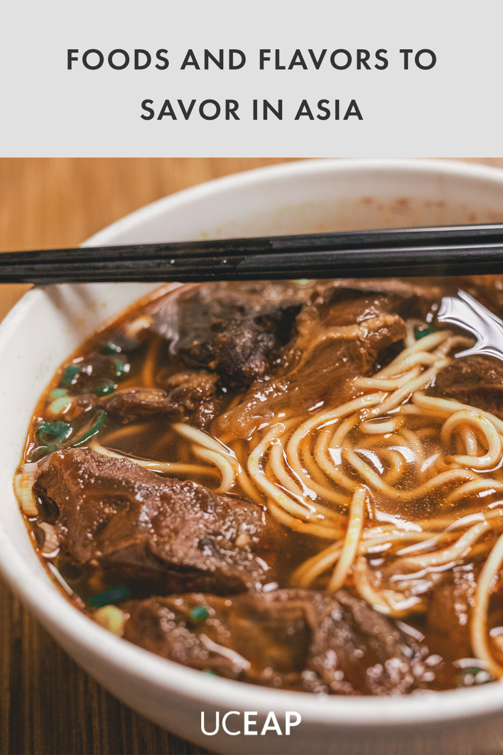 Beef and noodles with chopsticks in a white bowl.