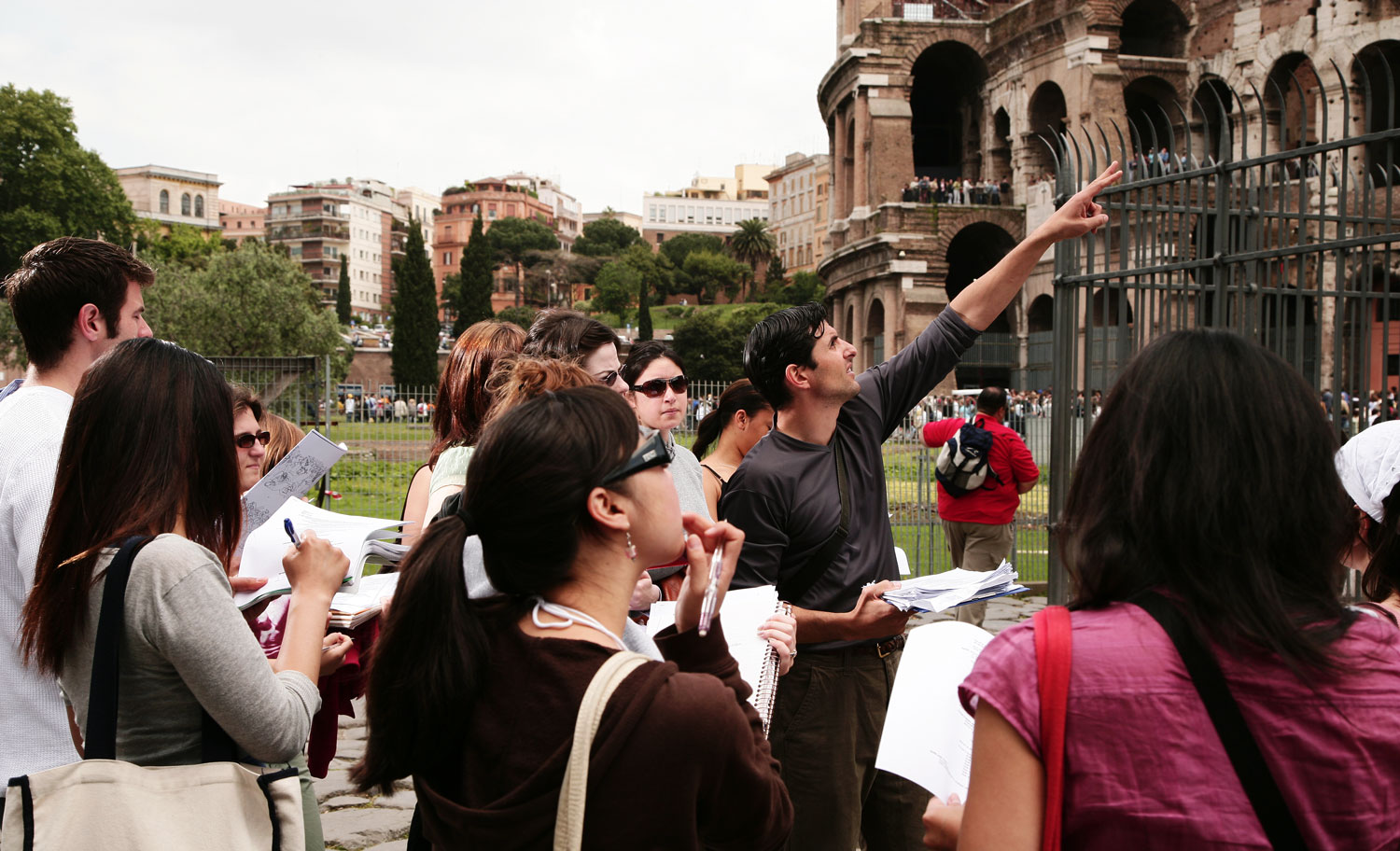 A teacher pointing to a monument in front of other students