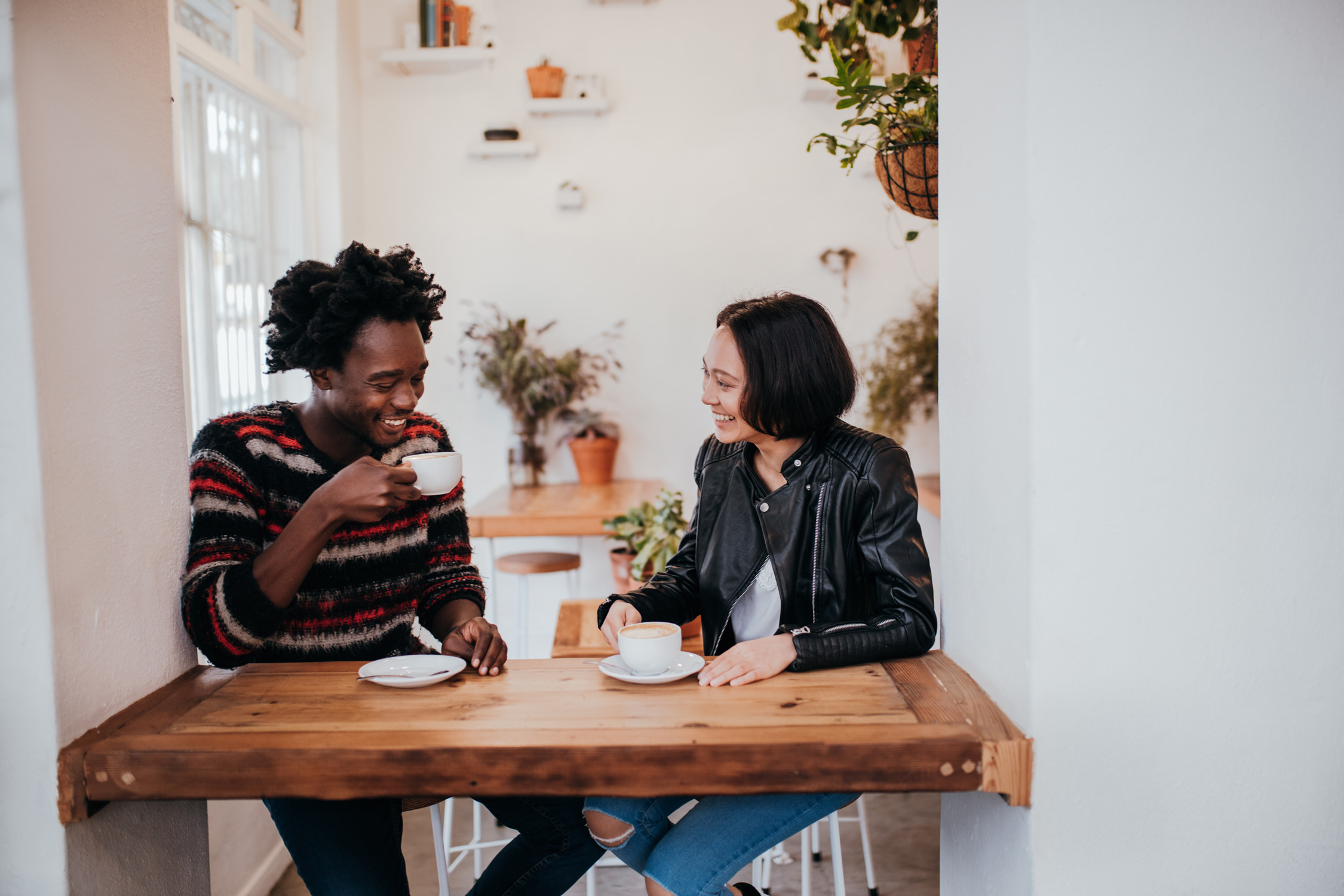 two friends sitting and talking at a cafe