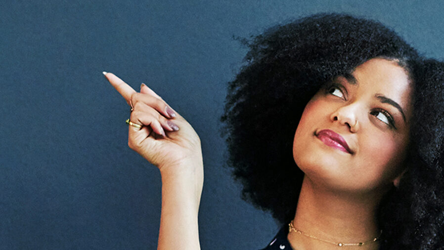 Young woman pointing upward with blue background