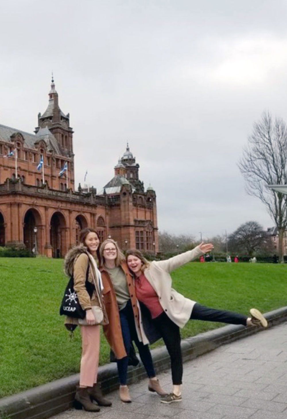 Christine Choy smiling at the camera with two friends in front of the Kelvingrove Museum, Glasgow