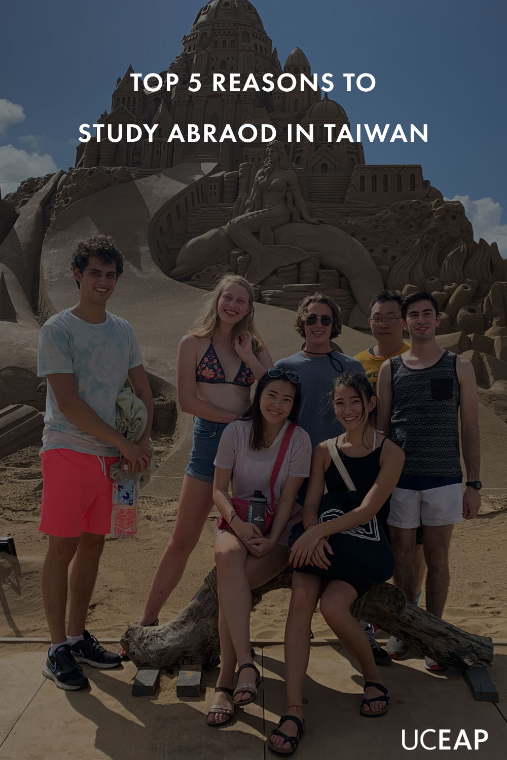 Student from UC Berkeley poses with friends at sand sculpture in Taiwan.
