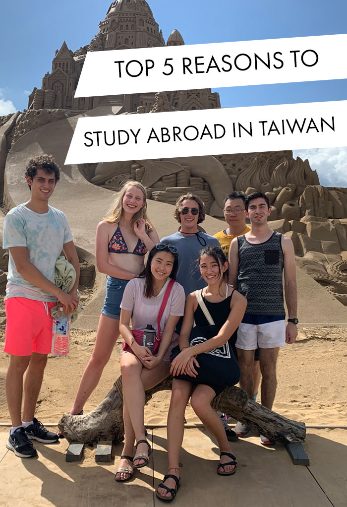 Student from UC Berkeley poses with friends at sand sculpture in Taiwan.