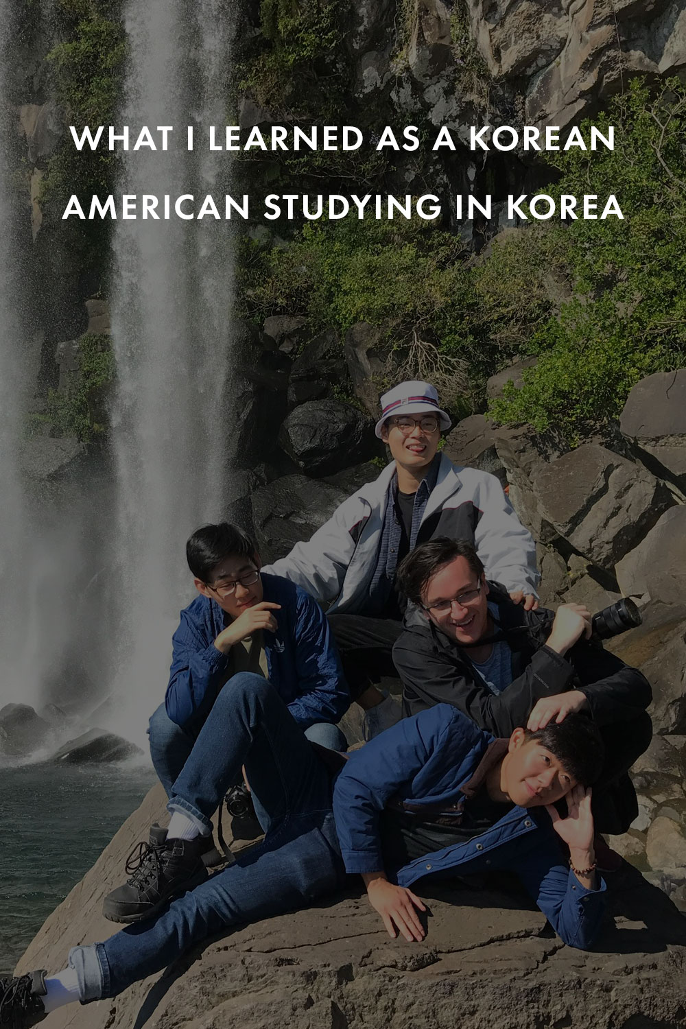 Four friends posing near a waterfall in Korea. 