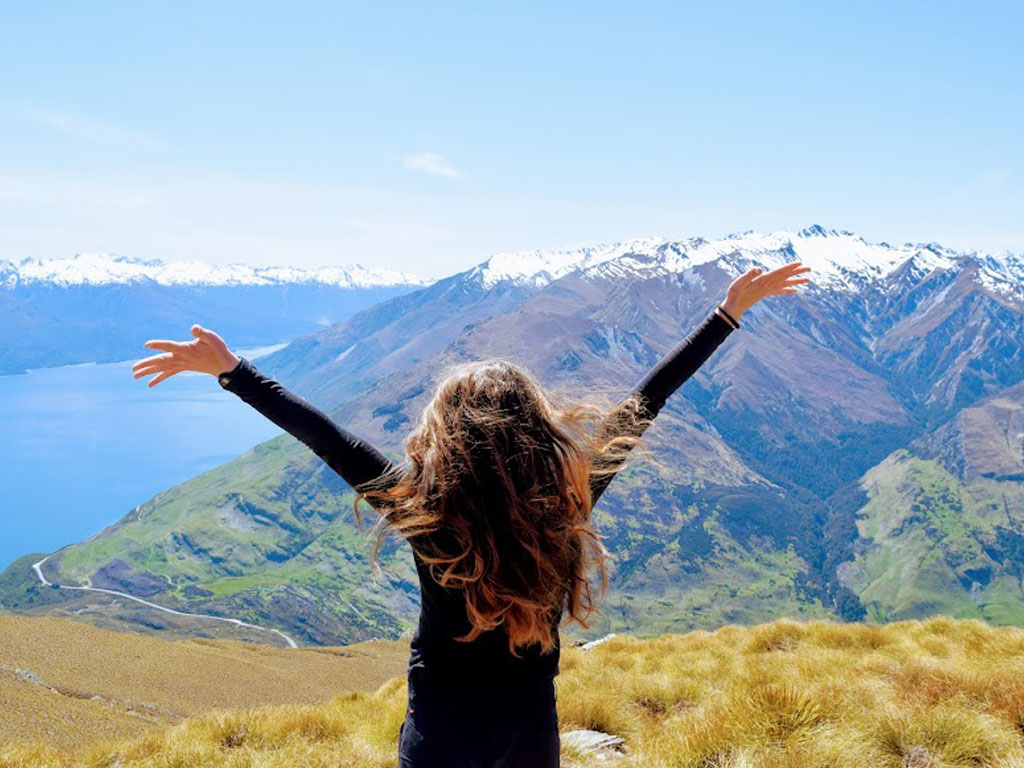 Sierra with her arms in the air and enjoying the view of New Zealand.