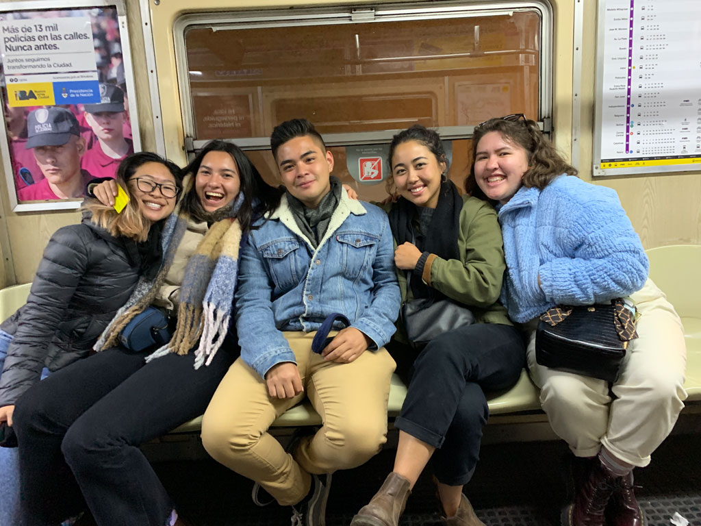 Ramil and friends smiling for the camera while on public transportation