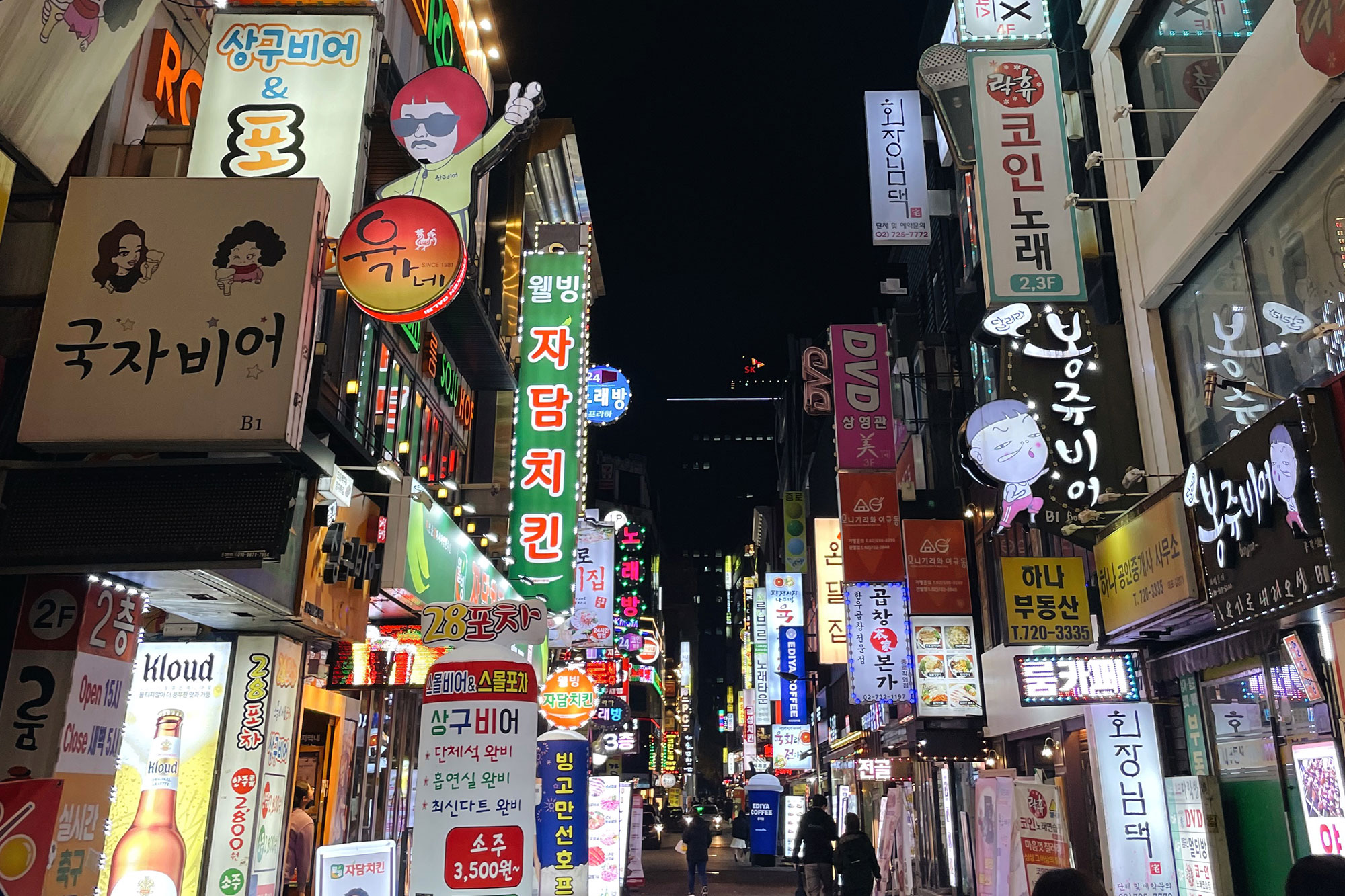 Nighttime view of downtown Seoul street, South Korean town lined with neon and lighted store and advertising signs
