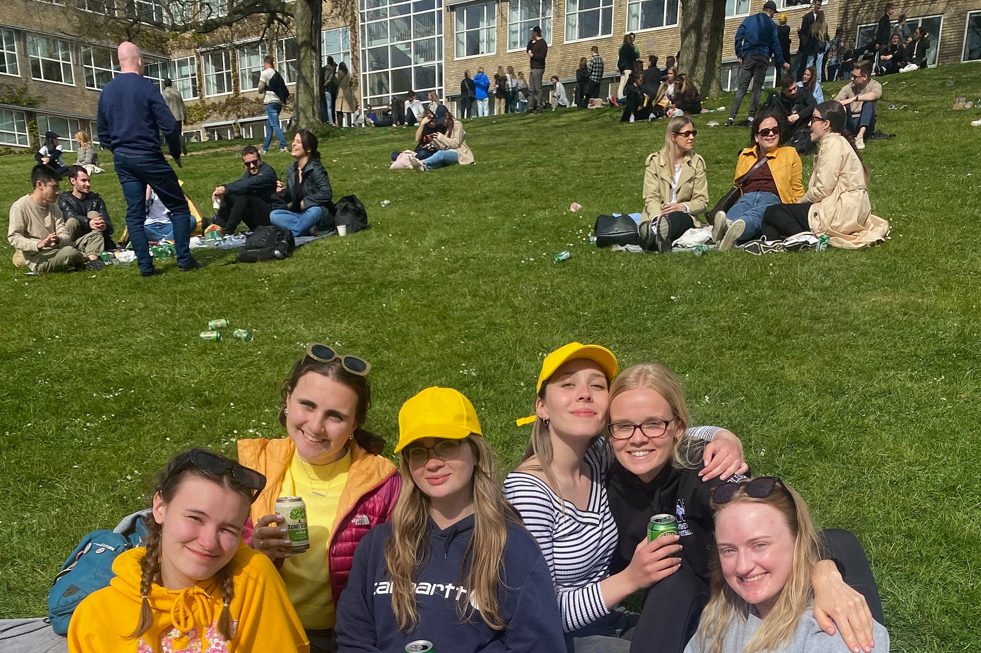 Group of students gathered on grass on campus, Aarhus, Denmark.