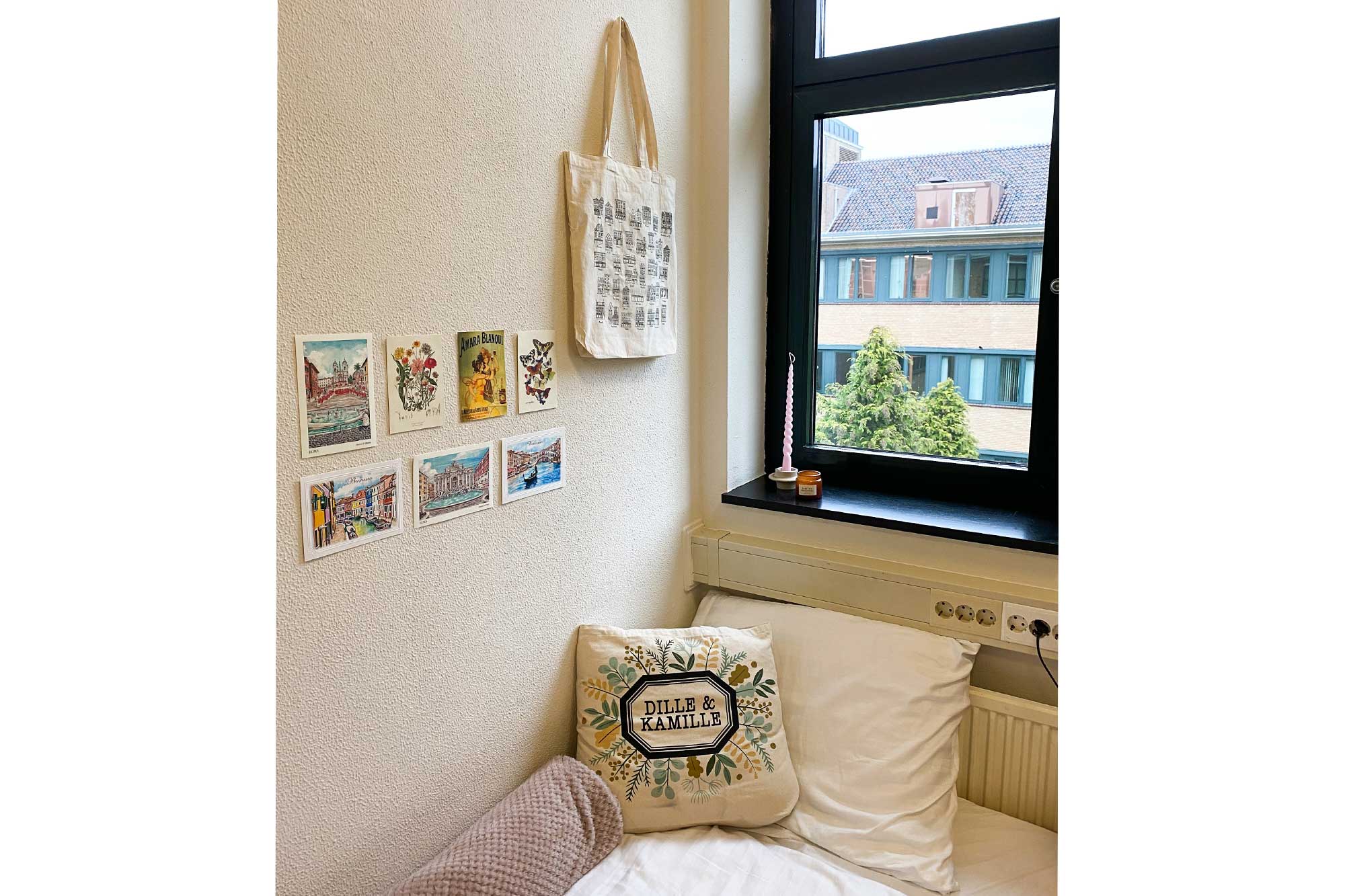 A cozy window corner of guest room with postcards on wall at the UM Guesthouse, Maastricht