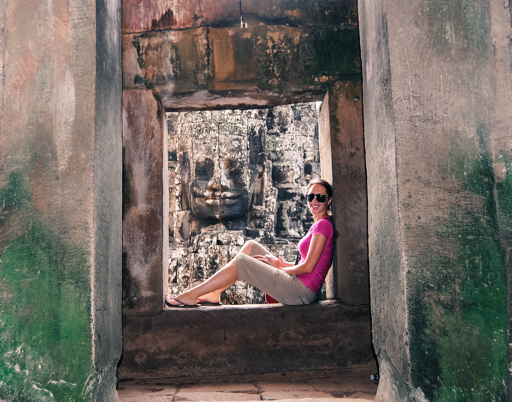 Kristin Addis sits and poses for a photo inside of a square-shaped rock structure.