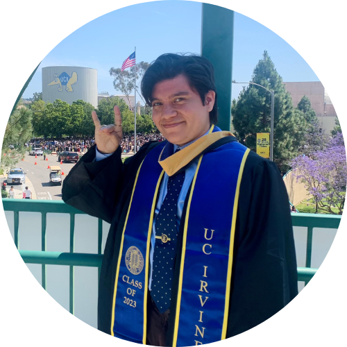 Joshua Swank does the anteater hand symbol while posing for a picture at UC Irvine graduation.