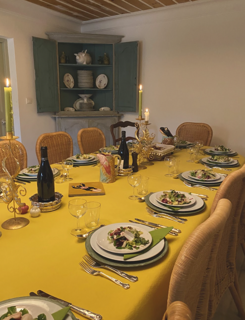 A table is set with plates and glasses on a yellow cloth.
