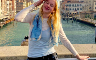 Student posing in front of a picturesque canal