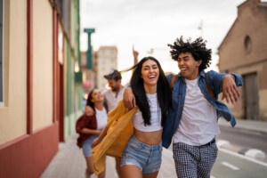 Young adults walking on the street, having fun with their friends and enjoying the moment. 