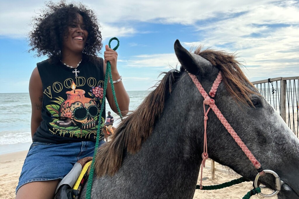 Tanesia Williams riding a horse on the beach in Ghana