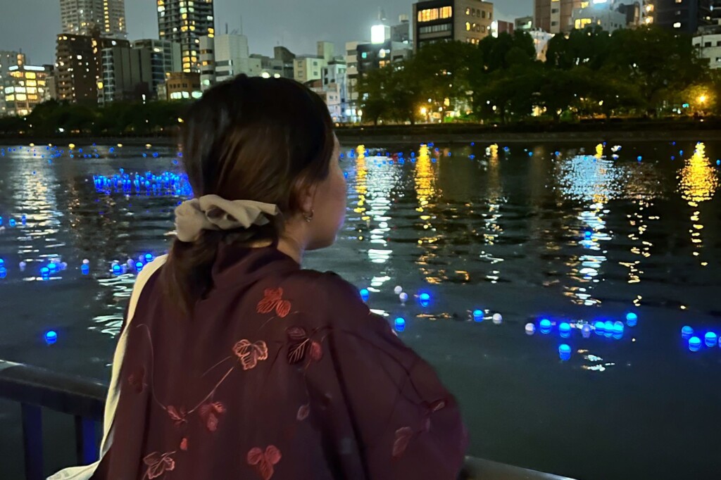 Student overlooking the harbor at night