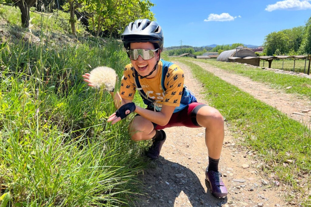Marisol Mendoza beside a bike track showing off a roadside bloom