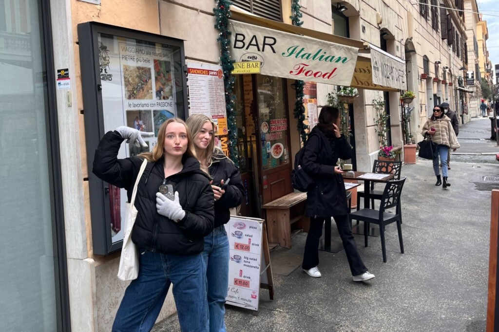 Monique Evdokiou and friend outside restaurant in Italy