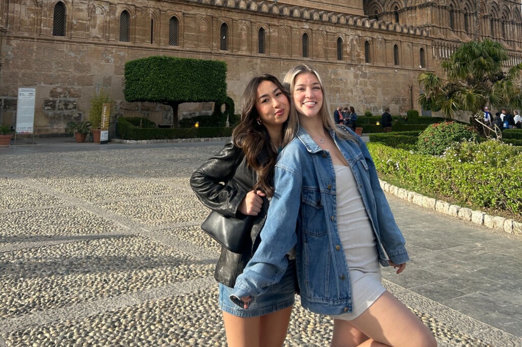Students abroad posing in front of stone building