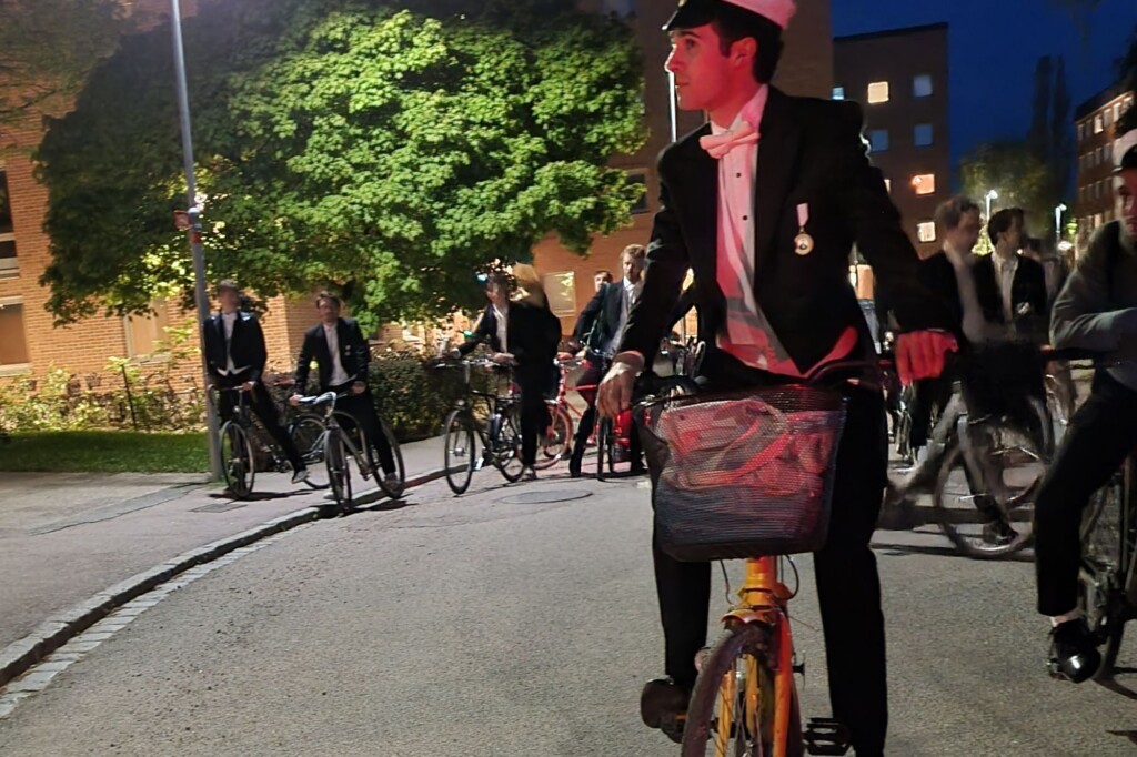 Max Morena (UC Berkeley cycling in Uppsala in a black tailcoat and tie