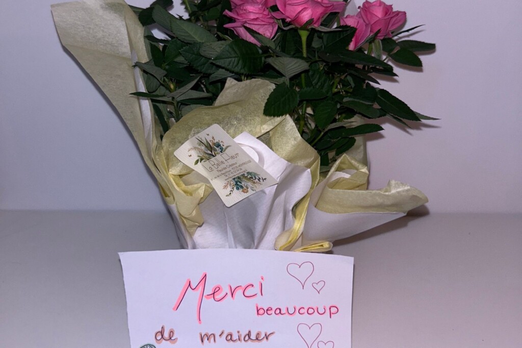 Bouquet of thank-you roses with note written in French