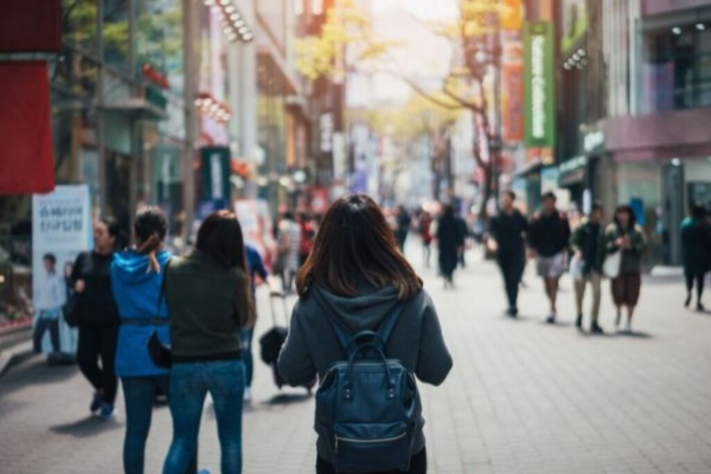 Student with backpack in Asian country looking down street