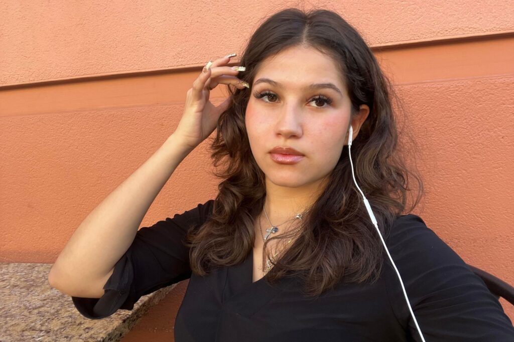 Terra with  headphones and a new mindset sitting against a wall